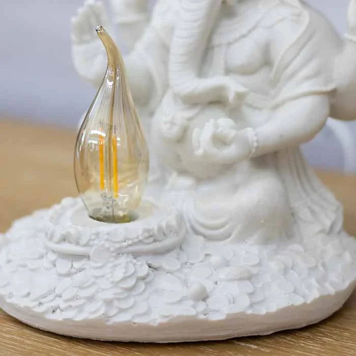 Imagem de Ganesha para iluminação decorativa em mesa de cabeceira, criando uma atmosfera acolhedora e mística.