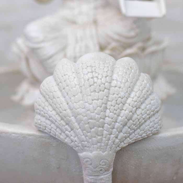 Imagem de Lakshmi sentada em lótus com luz interna refletindo no movimento da água da fonte artesanal.
