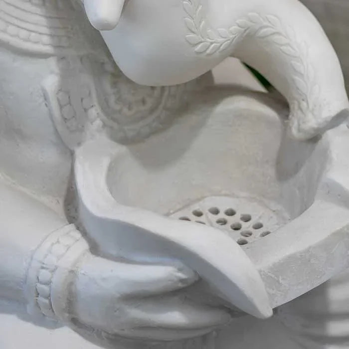 Objeto com representação de Ganesh e base em cimento, com acabamento detalhado.