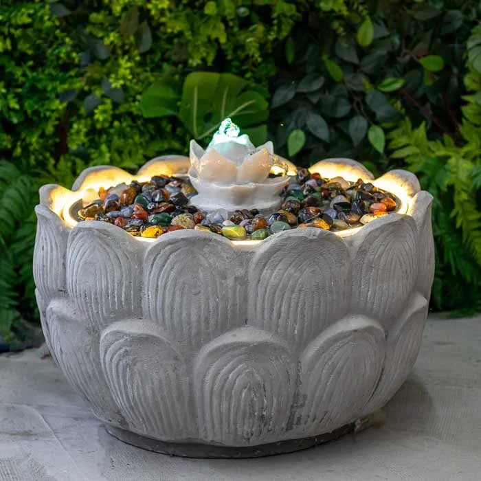 Nascente circular em fibrocimento com flor de lótus iluminada