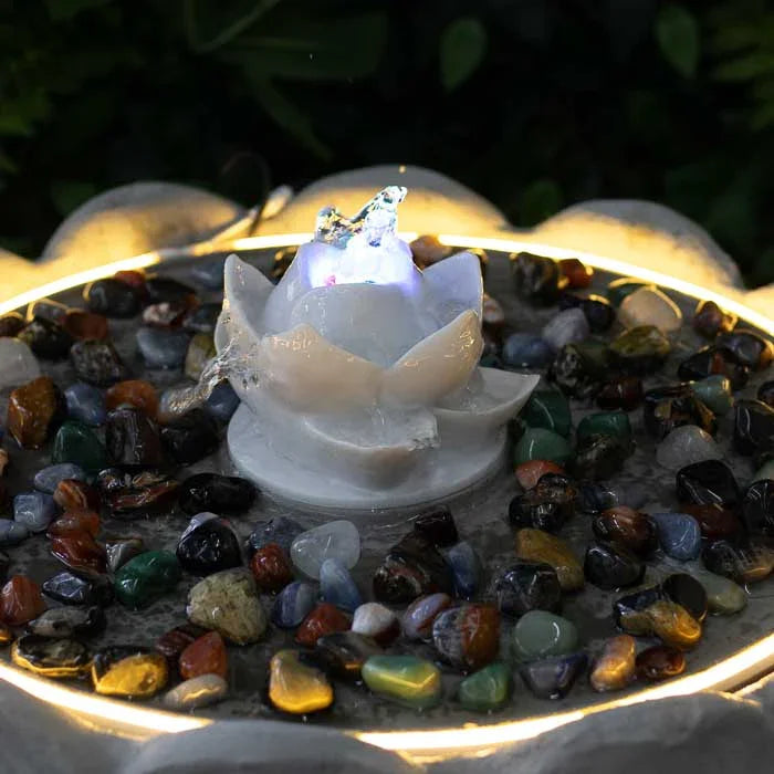 Peça zen com base cinza clara, flor branca e pedras decorativas