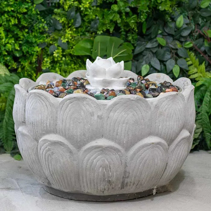 Fonte decorativa com iluminação suave e pedras coloridas ao redor