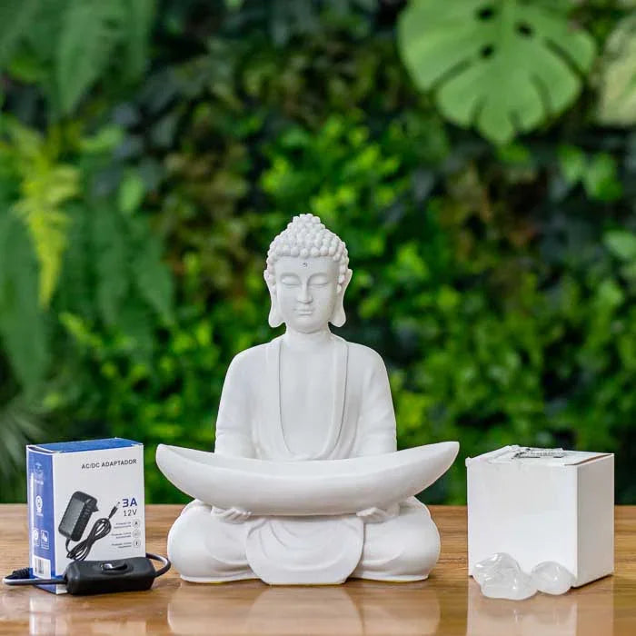 Buda meditativo com pedras claras iluminadas sobre as pernas