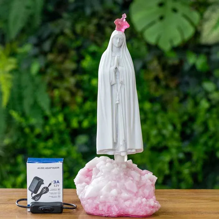 Escultura branca de Fátima com expressão serena e luz rosa