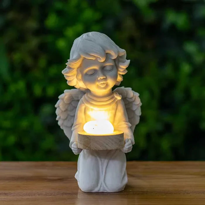 Escultura de anjo criança ajoelhado com pedra iluminada nas mãos