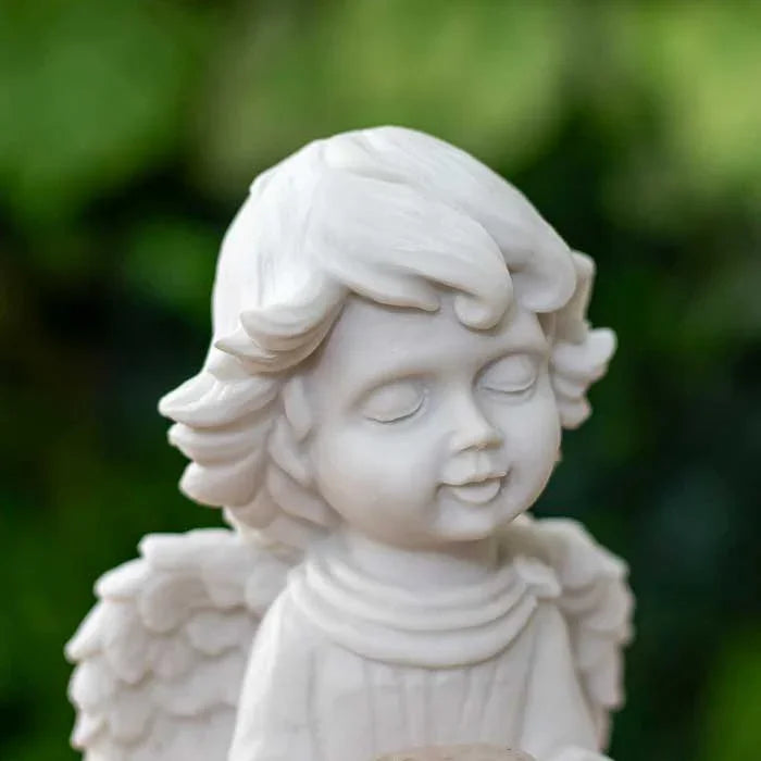 Anjo infantil com asas visíveis e luz suave em pedra central