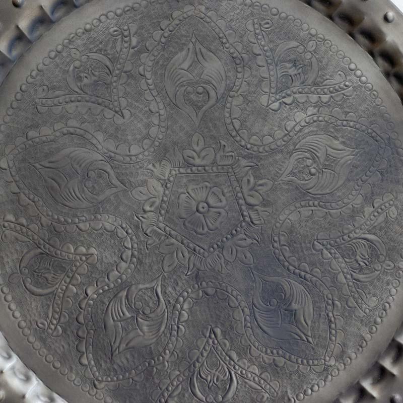 Detalhe frontal de mandala indiana evidenciando a simetria dos desenhos manuais e a borda pontilhada em relevo.