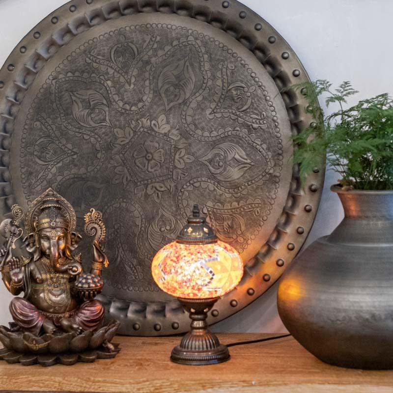 Decoração espiritual de grande porte com mandala de metal indiano em ambiente de sala de estar.