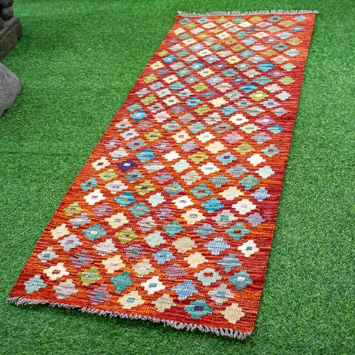 Passadeira Kilim em tear tradicional com padrões florais exclusivos.