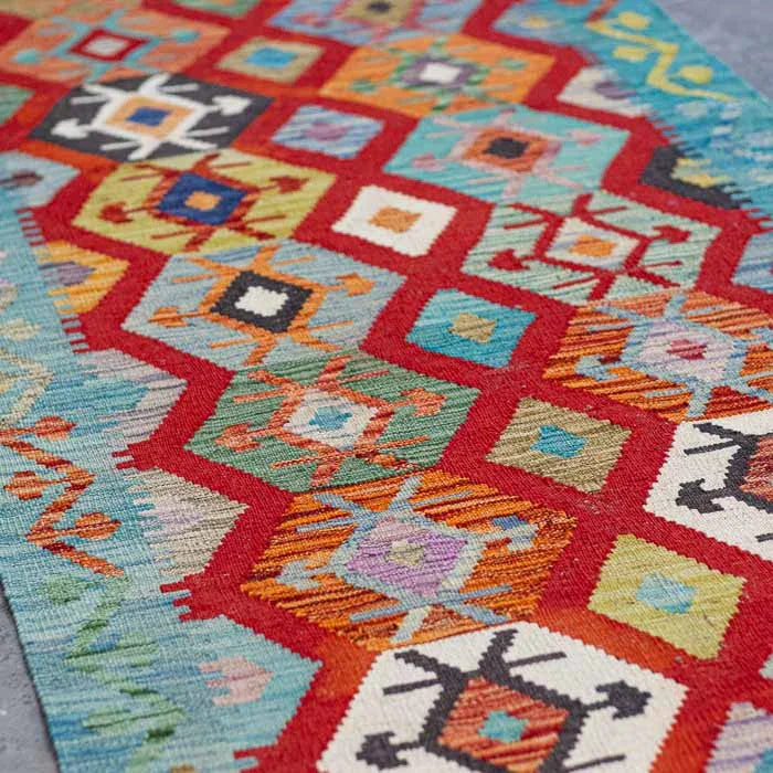 Tecelagem manual afegã em tapete Kilim rústico vibrante para hall de entrada e decoração de interiores sofisticada.