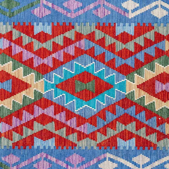 Passadeira Kilim afegã artesanal com bordas azuis e losangos coloridos geométricos.