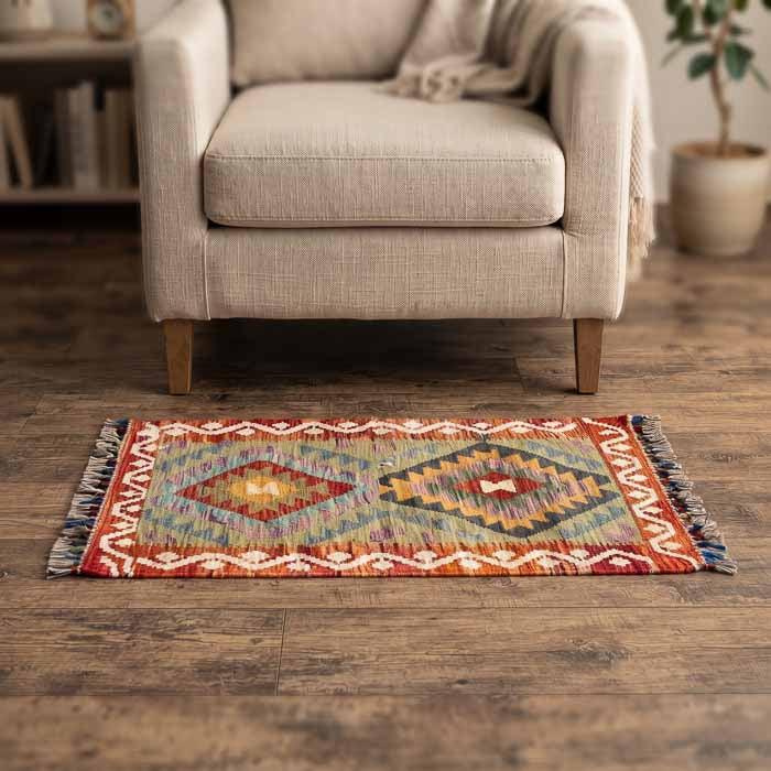 Peça Kilim afegã oriental de 94x61cm em dormitório com móveis claros e design orgânico exclusivo ao pé da cama.
