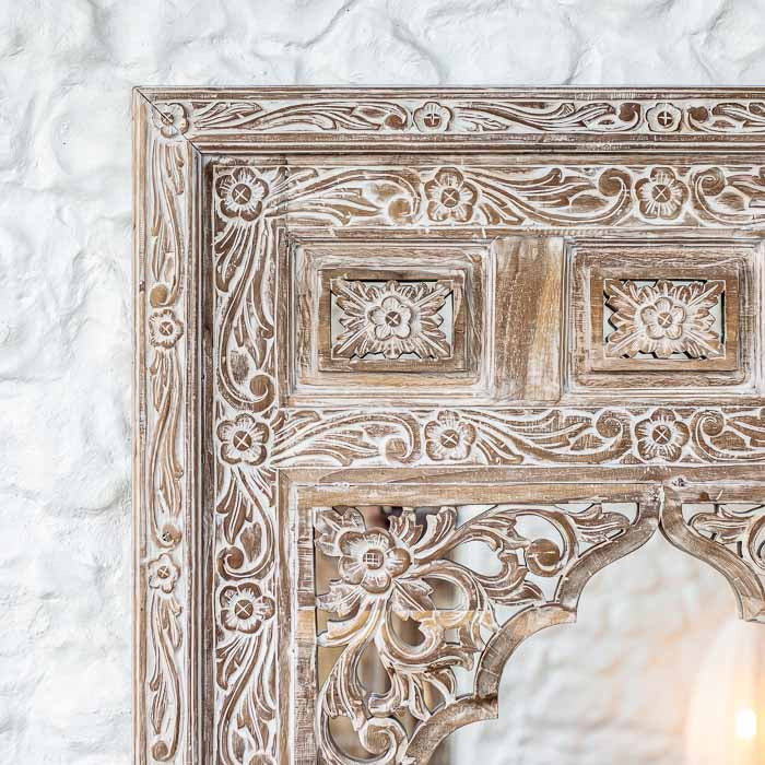 Moldura decorativa de espelho em madeira maciça com entalhes florais em relevo e topo em arco trabalhado.