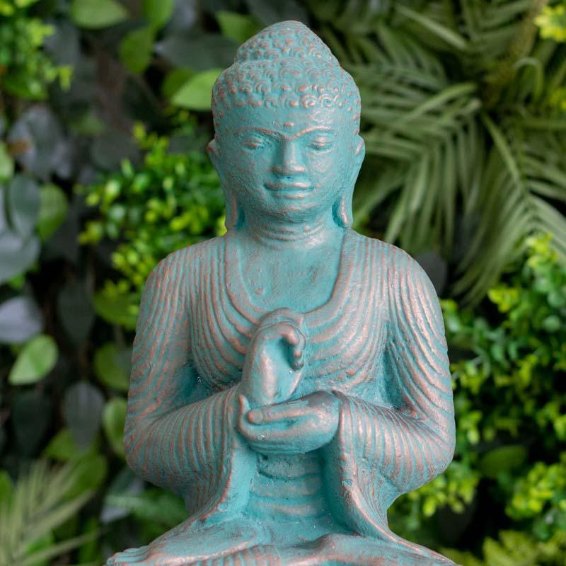 Escultura de jardim representando Buda em postura meditativa.