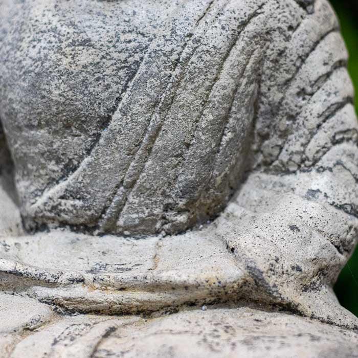 Objeto decorativo de cimento com simbolismo budista e estética balinesa.