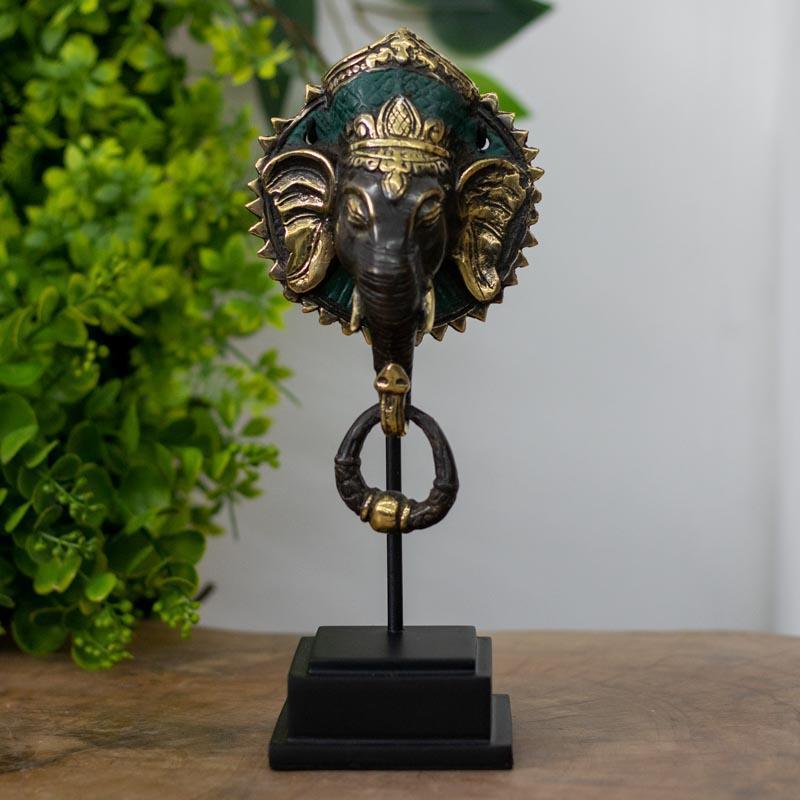 Escultura Ganesh Face de Bali em bronze com detalhes dourados e verde.