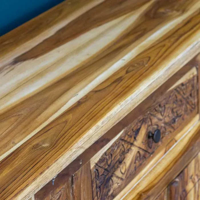 Móvel de apoio em madeira teca com pintura patinada, expressando arte e sofisticação natural.