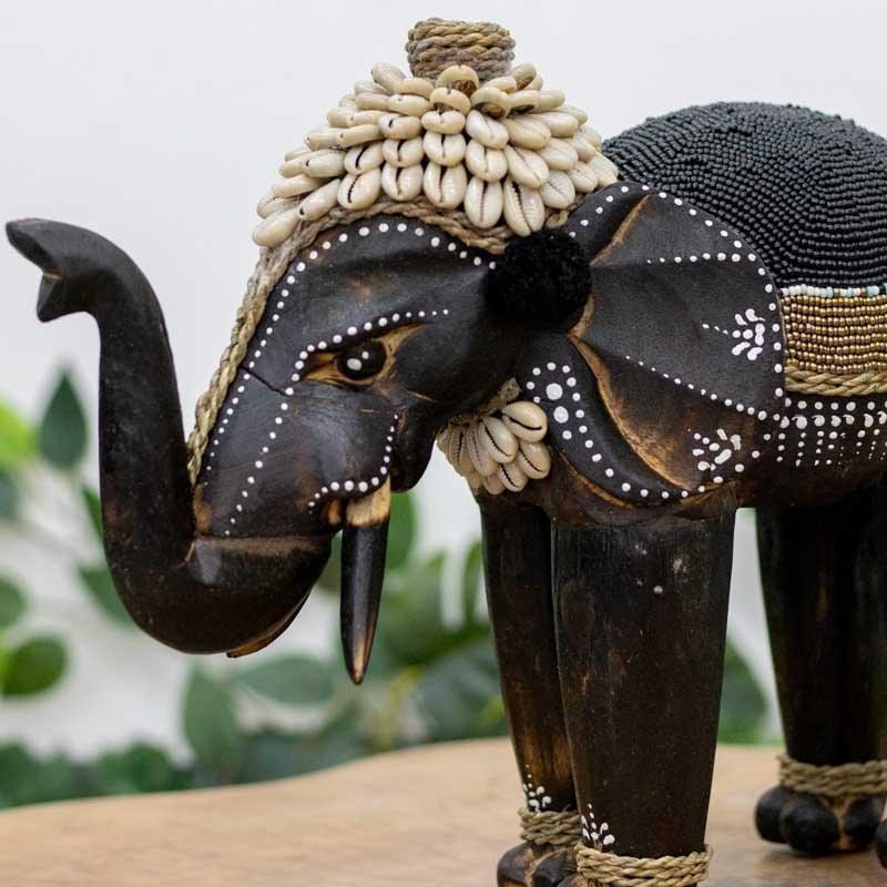 Elefante entalhado em madeira com aplicação de búzios artesanais.