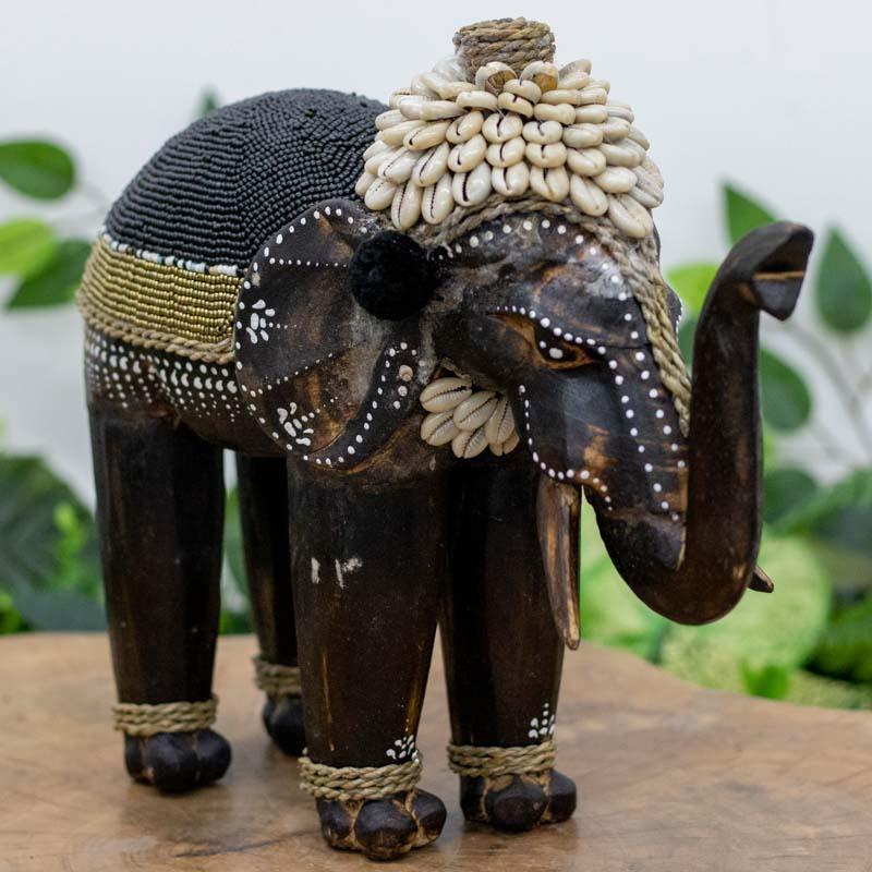 Escultura decorativa de elefante em madeira e búzios feita à mão.