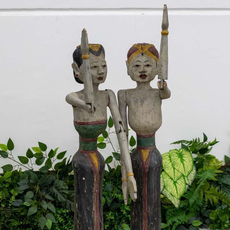 Trabalho manual indonésio em madeira: bonecos tradicionais com braços articulados e pintura artística simulando antiguidades orientais.