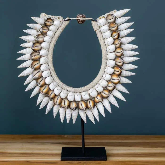 Colar de conchas sobre suporte, ideal para decoração com estilo boho.