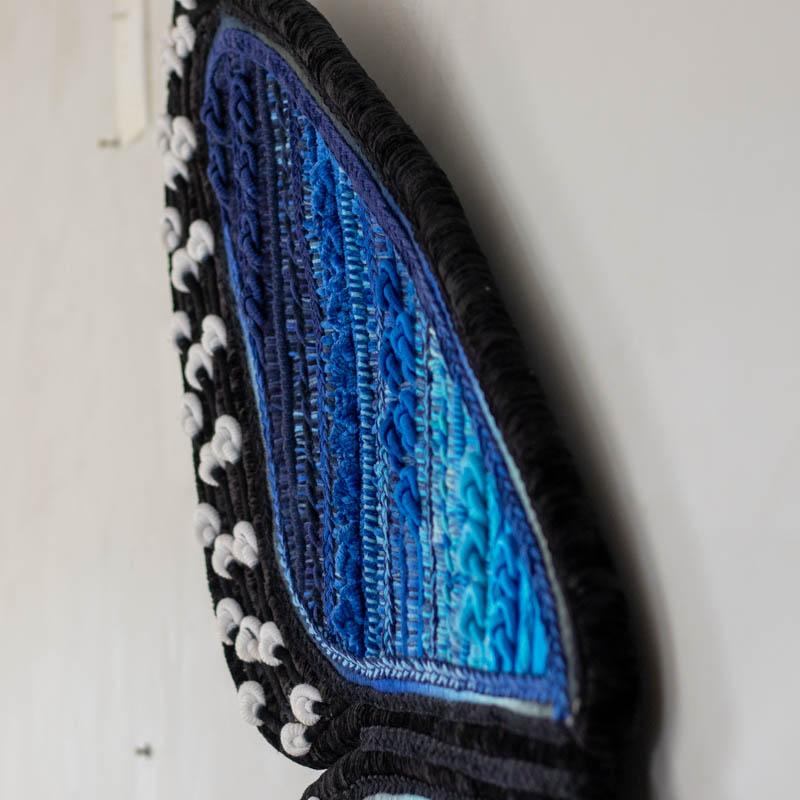 Obra de arte sustentável do artista Glauber Rodram, representando a asa esquerda de uma borboleta com bordas pretas e pontos brancos.