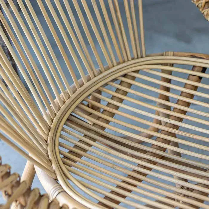 Poltrona com estrutura em rattan natural, linhas suaves e visual leve, ideal para espaços relaxantes e elegantes
