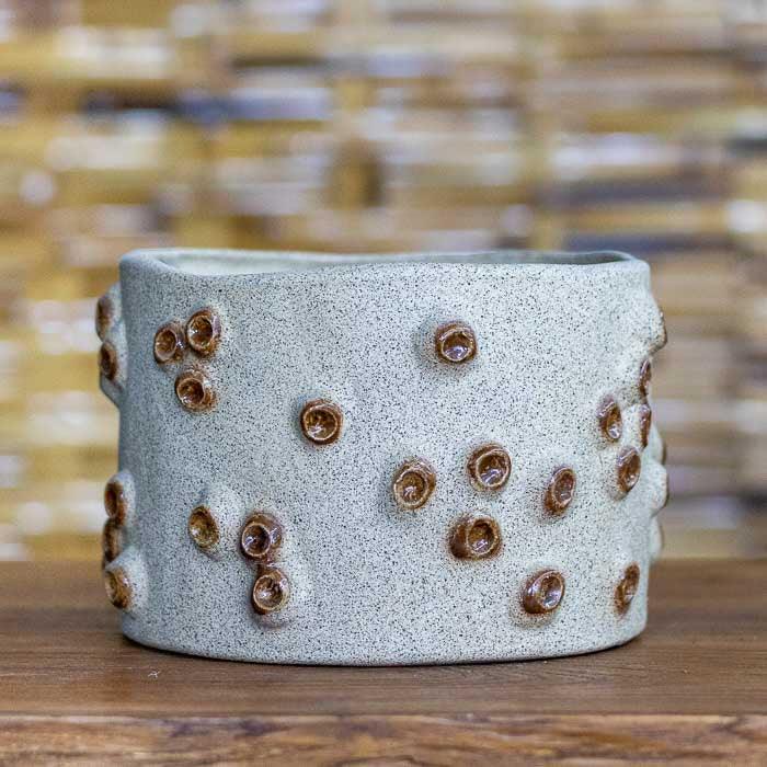 Cachepot de cerâmica com efeito craca, ideal para plantas e decoração.