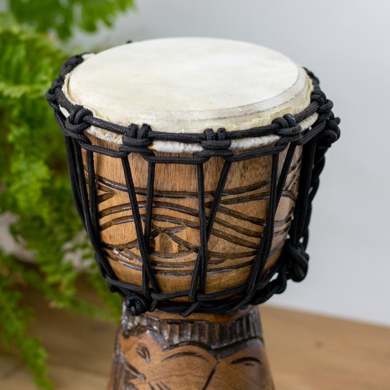 Instrumento balinês com corpo entalhado em madeira, destacando um elefante em traços étnicos e detalhados