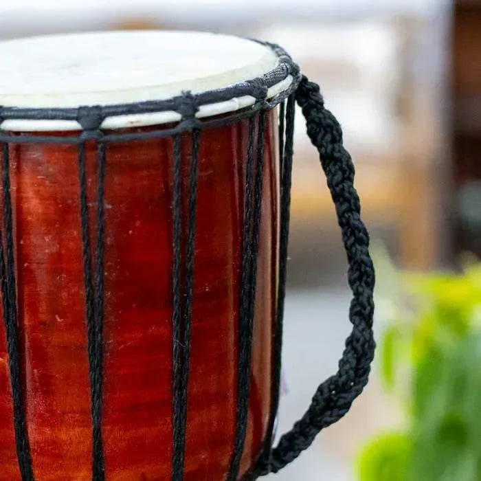 Instrumento africano djembê com arte balinesa, confeccionado artesanalmente com detalhes pintados à mão e textura natural da madeira.