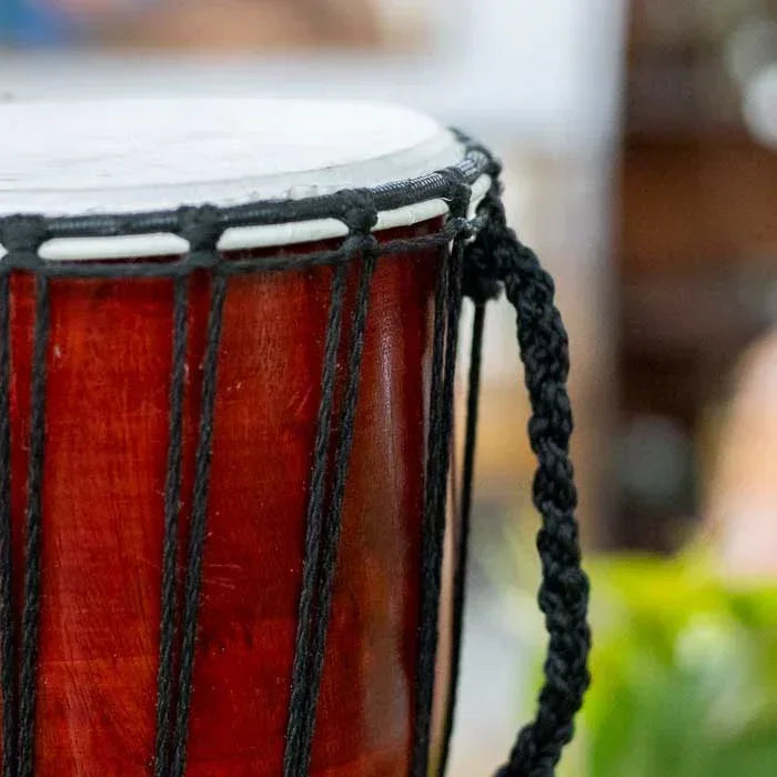 Djembê étnico de madeira e couro natural feito à mão em Bali, pintura artesanal colorida que representa espiritualidade, som e tradição cultural.