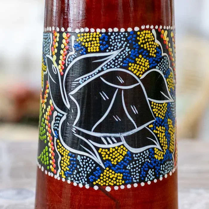 Detalhe do djembê artesanal com pigmentos e desenhos étnicos, tambor feito à mão em madeira com acabamento envernizado natural.