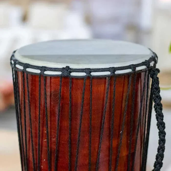 Djembê artesanal feito à mão em madeira nobre e couro natural, com pinturas coloridas de Bali que representam a união entre ritmo, arte e espiritualidade.