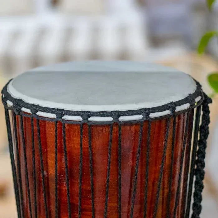 Tambor de percussão africano com arte balinesa, feito à mão em madeira e couro natural, perfeito para decoração étnica e ambientes com energia ancestral.