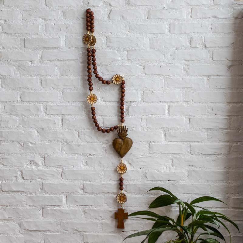 Objeto de decoração religiosa em madeira natural, trazendo o simbolismo do coração em chamas para o design moderno.