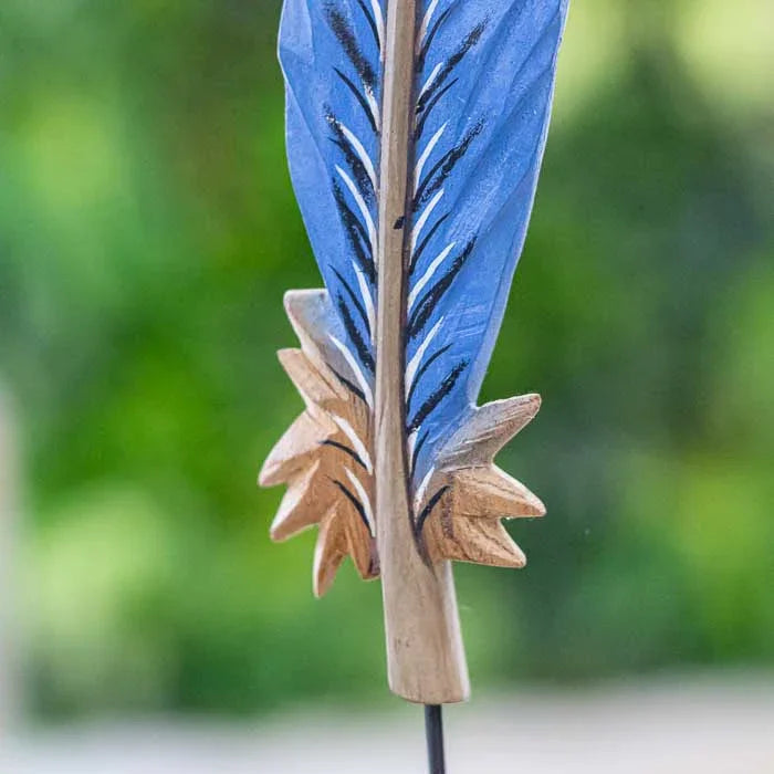 Arte brasileira em madeira com símbolo espiritual de leveza e proteção.