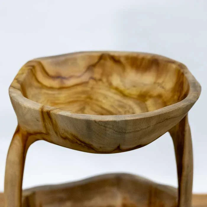 Objeto decorativo artesanal de Bali em madeira maciça, fruteira dupla com formas curvas e acabamento natural que destaca os veios e a textura da madeira.