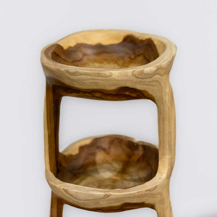 Peça artesanal balinesa com quatro níveis talhados em madeira natural, ideal para uso como fruteira ou elemento decorativo elegante.