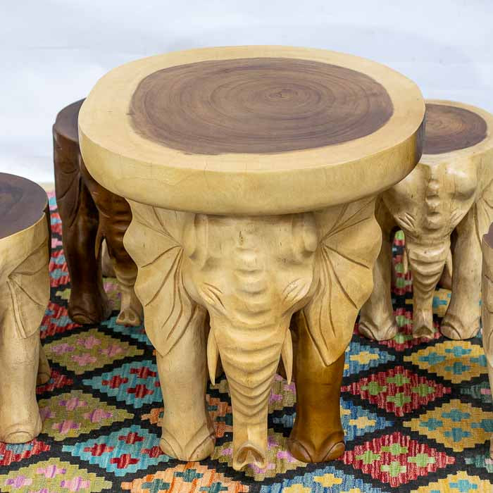 Mesa de centro em madeira Suar esculpida, com base formada por cabeças de elefante.