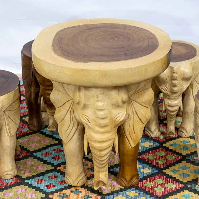 Mesa de centro em madeira Suar esculpida, com base formada por cabeças de elefante.