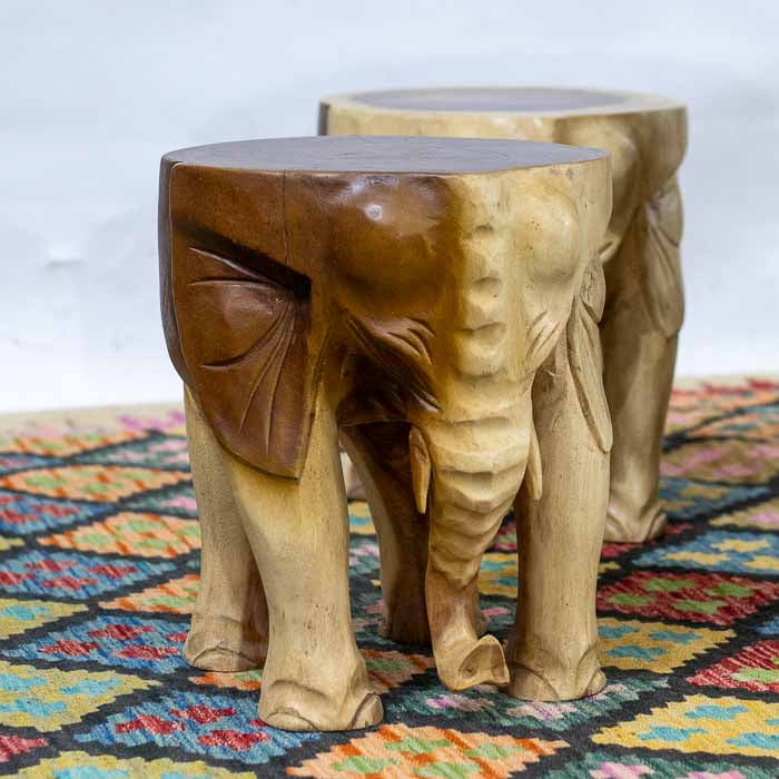 Detalhe do entalhe de elefante na mesa de madeira Suar, evidenciando o artesanato.