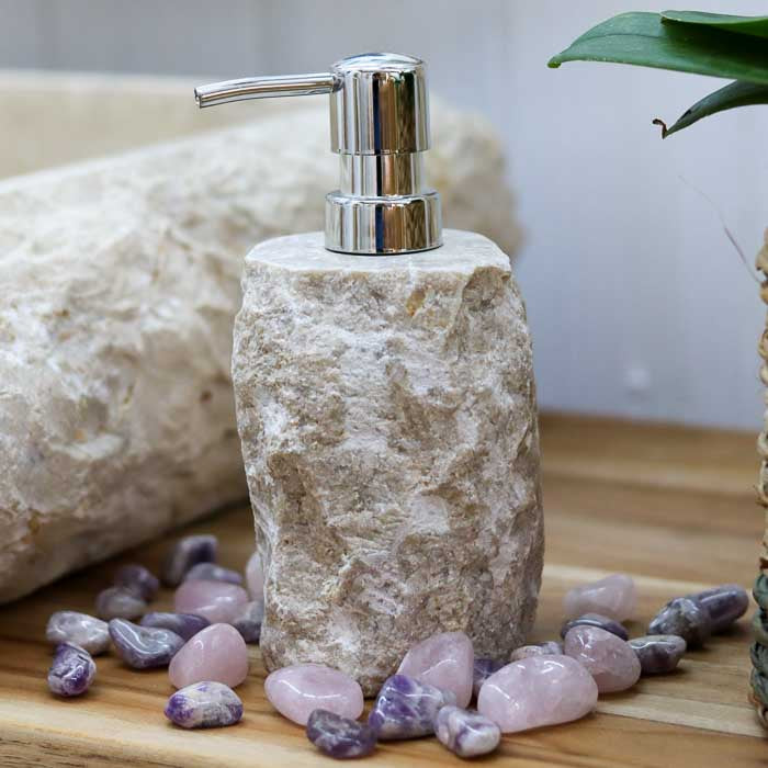 Saboneteira em pedra natural escura com válvula cromada ideal para sabonetes líquidos e óleos de cuidado diário.