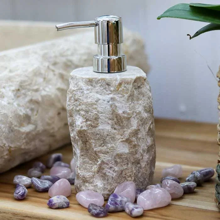 Saboneteira em pedra natural escura com válvula cromada ideal para sabonetes líquidos e óleos de cuidado diário.