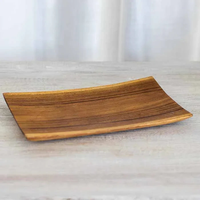 Trio de tábuas gourmet em madeira teca sobre superfície clara evidenciando o design orgânico.