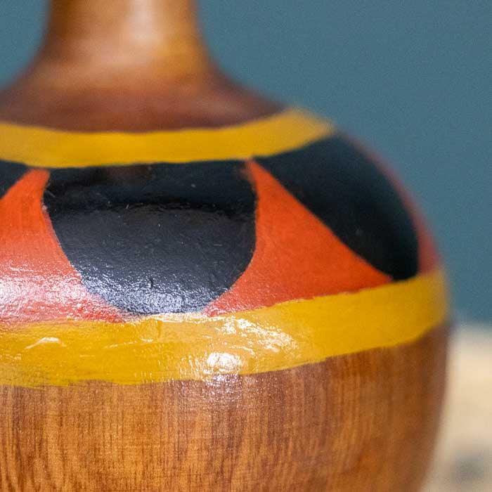 Objeto decorativo em madeira com design lúdico e acabamento rústico.