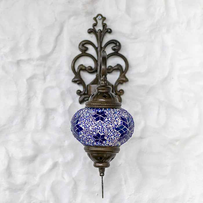 Detalhe da cúpula de vidro artesanal com mosaico azul e contas brancas em luminária de estilo oriental.