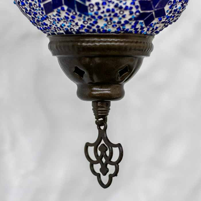 Iluminação decorativa exótica com arandela turca criando padrões de luz colorida em ambiente interno.