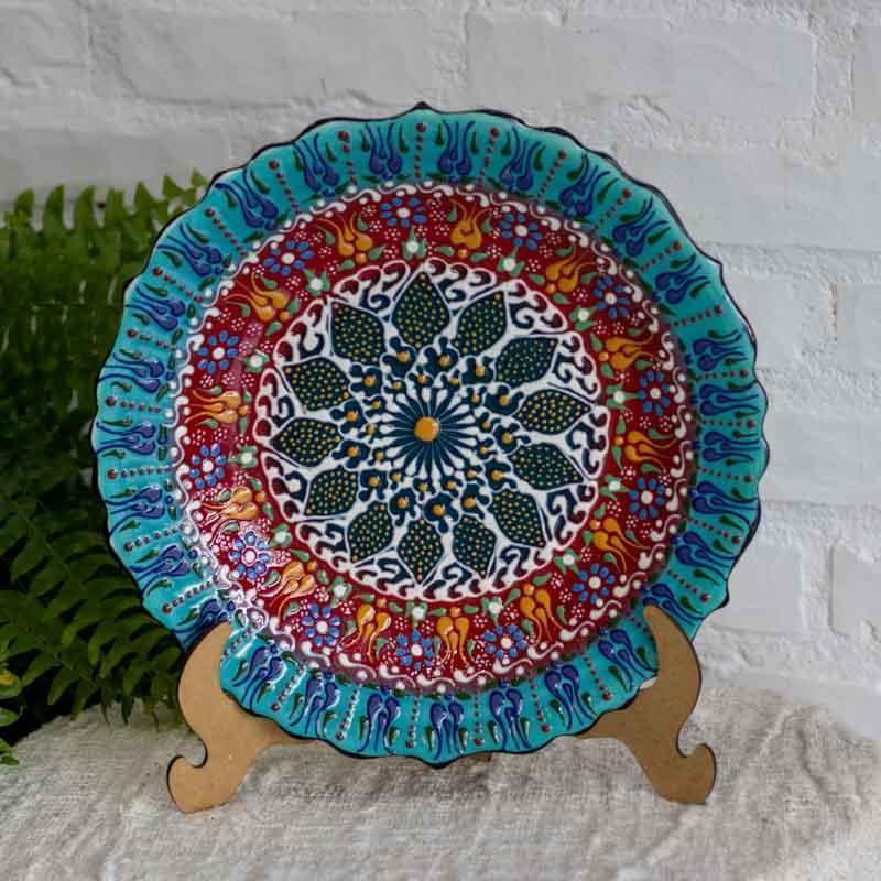 Detalhe da textura tátil de mandala floral em prato de cerâmica turca, destacando o brilho e a precisão do artesão.