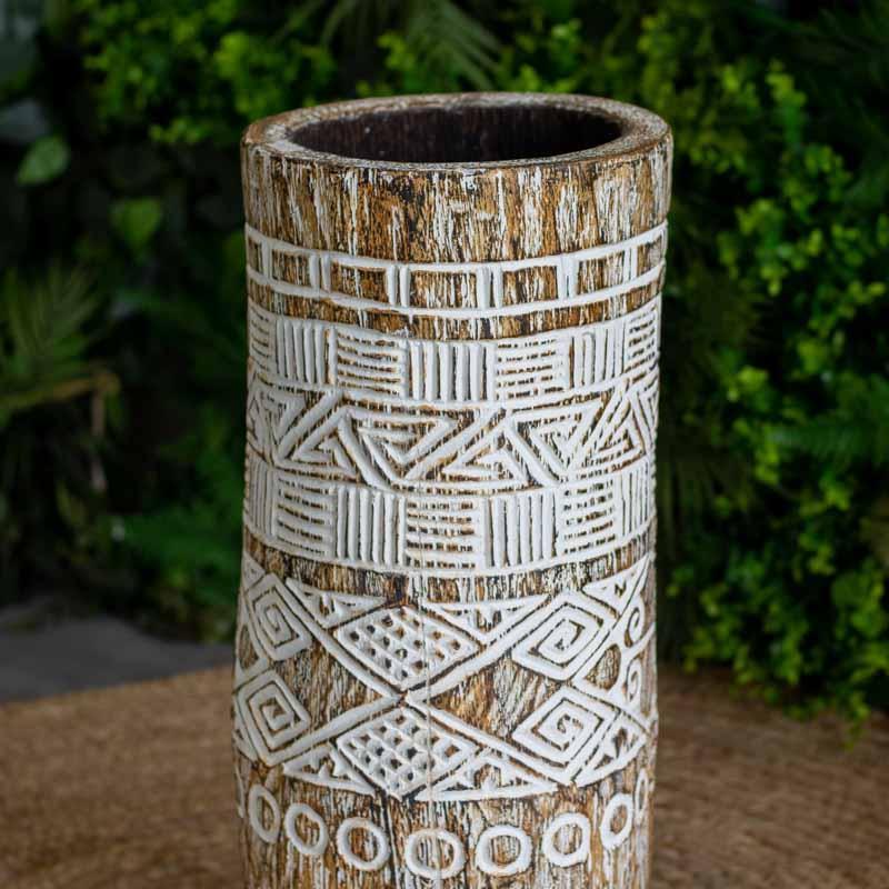 Vaso artesanal feito de tronco de palmeira natural de Timor, com entalhes tribais geométricos e acabamento em pátina branca.