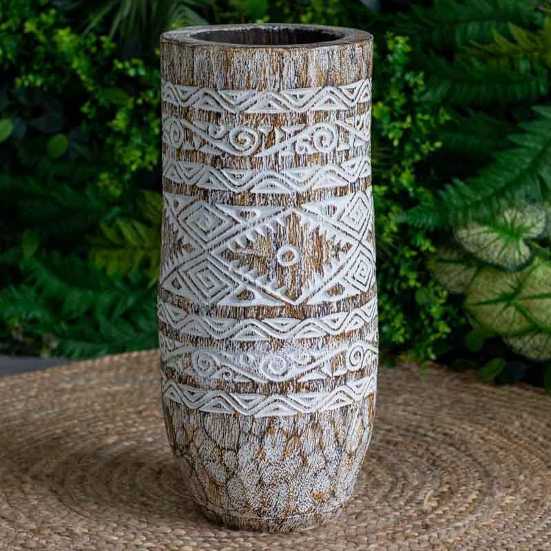 Objeto de arte primitiva da Indonésia esculpido em tronco de árvore, apresentando padrões de triângulos e linhas em baixo relevo.